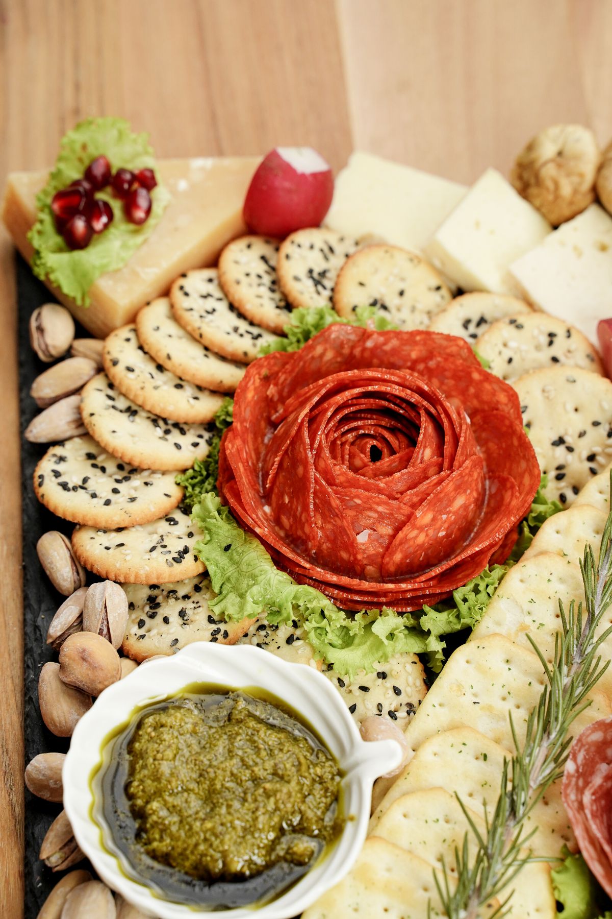 pepperoni rose on corner of charcuterie board with crackers and cheese