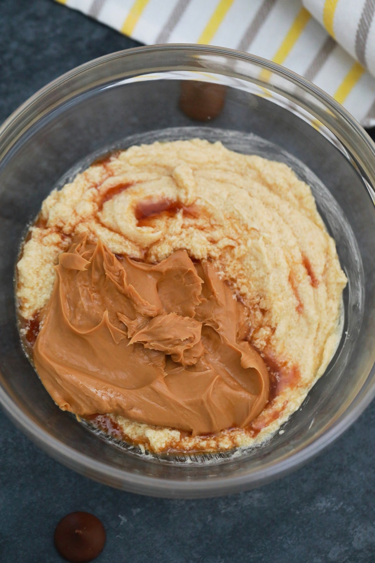 Adding peanut butter to cookie mixture in bowl