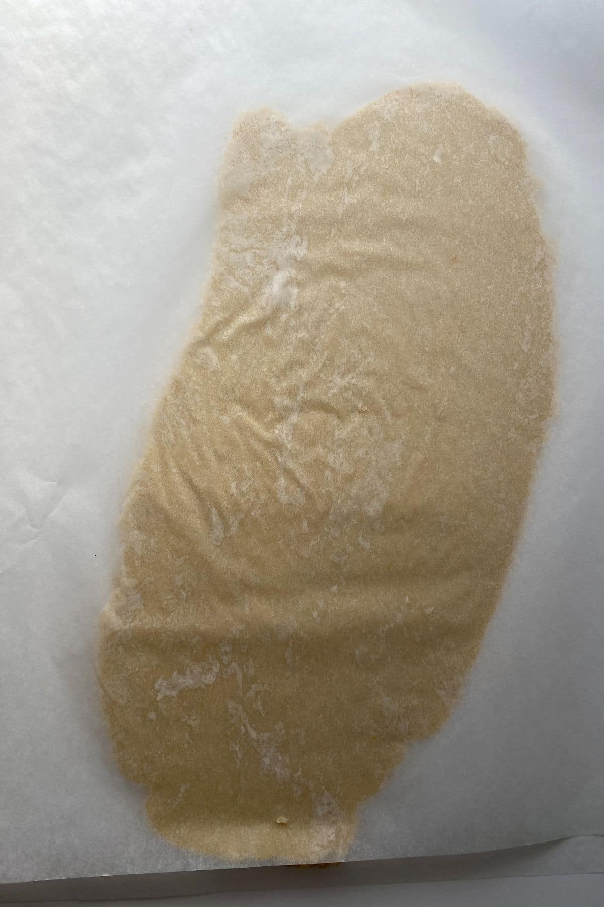 Dough between wax paper rolled flat