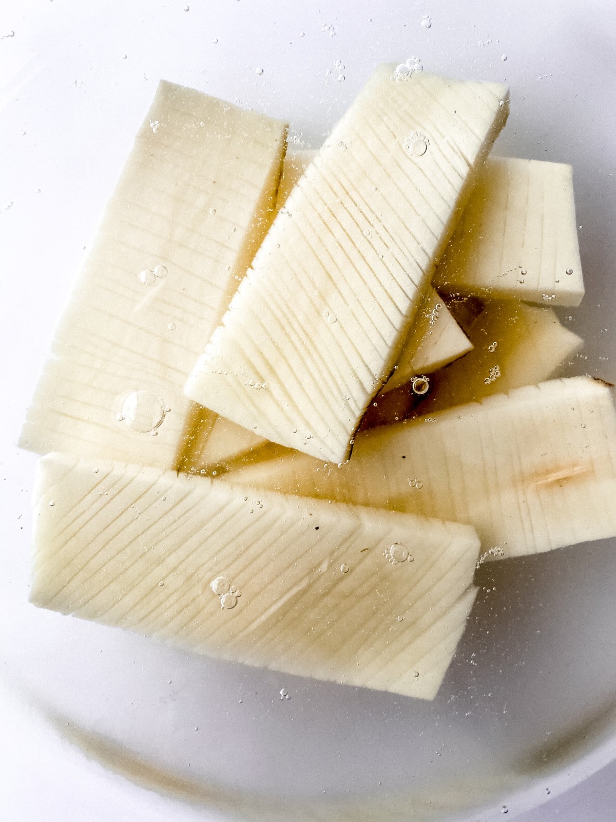 Sliced potatoes in bowl of water
