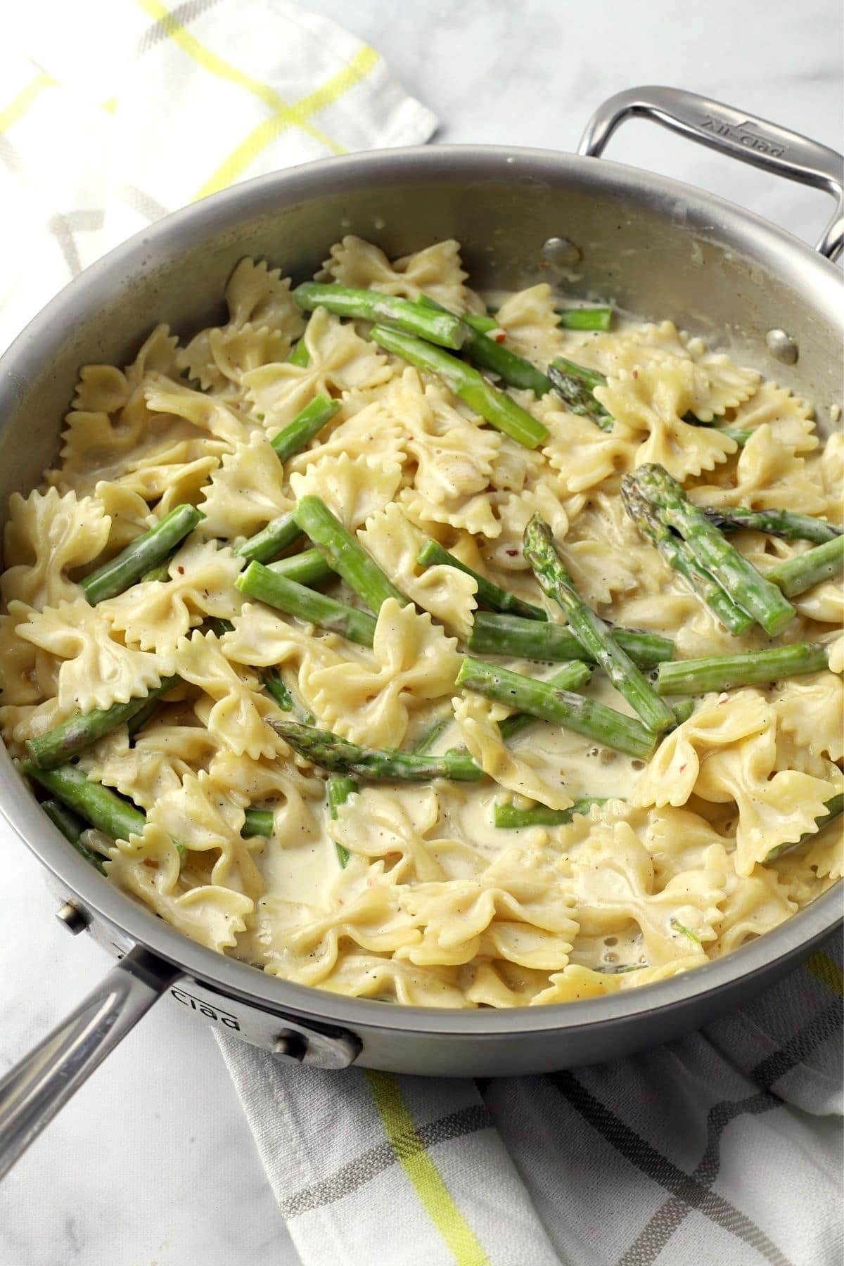 Bowtie pasta and asparagus in a cream sauce in skillet