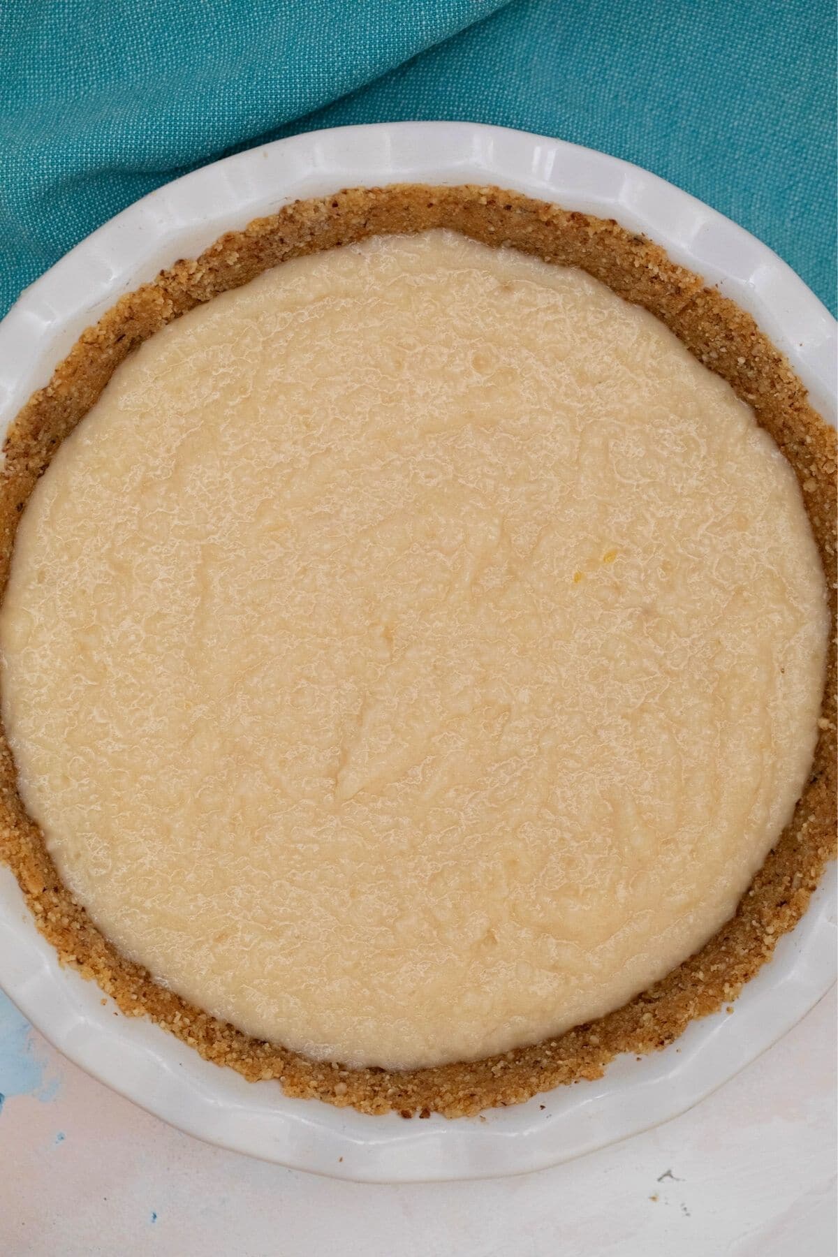 Pie filling in crust of pie in white pie plate