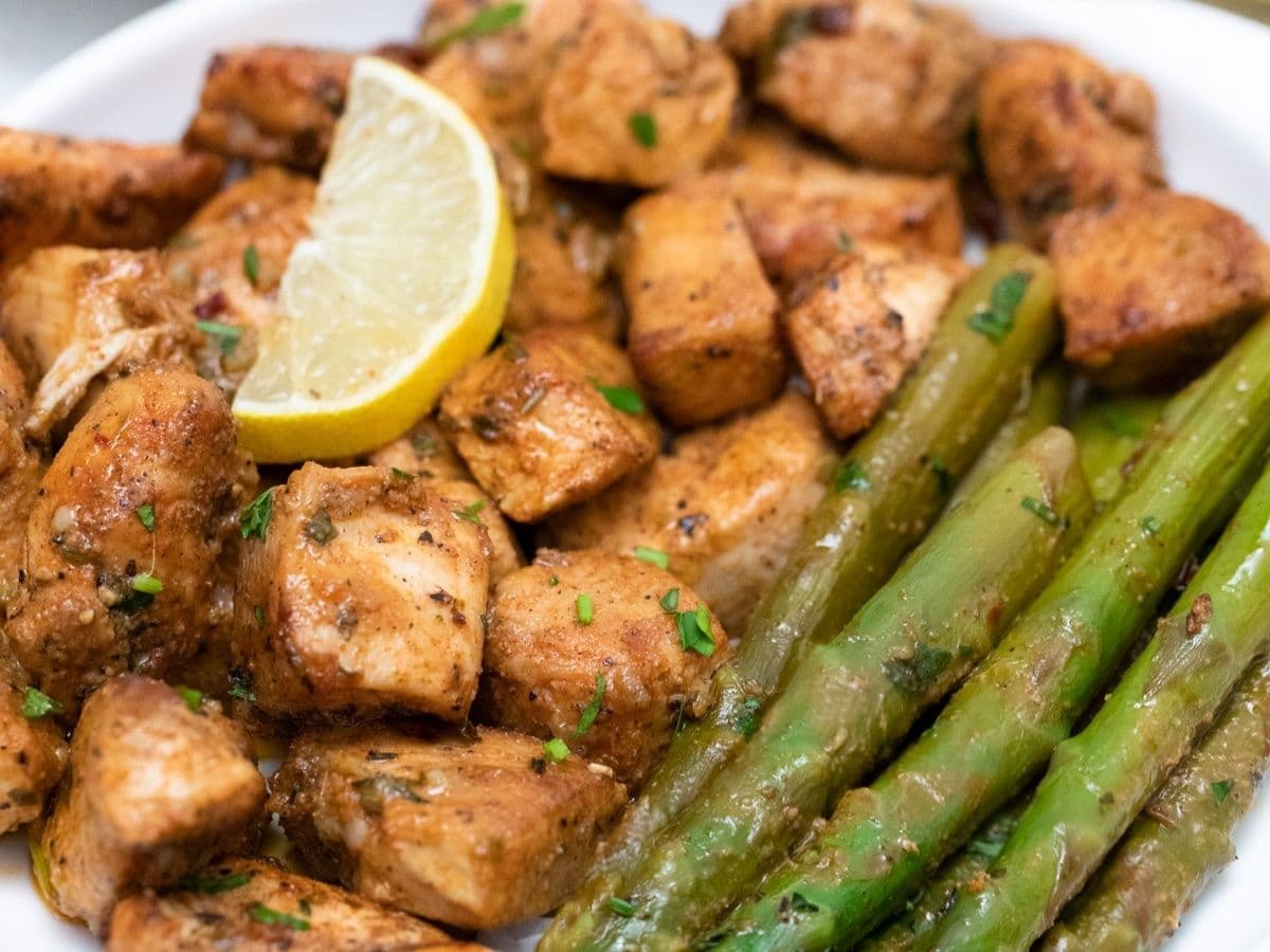 Chicken with slice of lemon on top and asparagus below