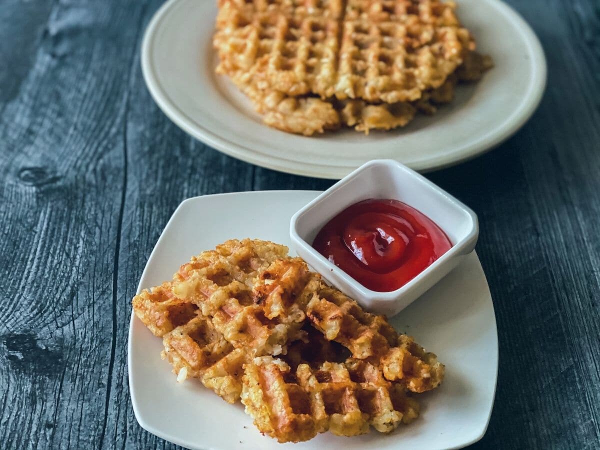 Waffle sticks on white saucer by ketchup bowl