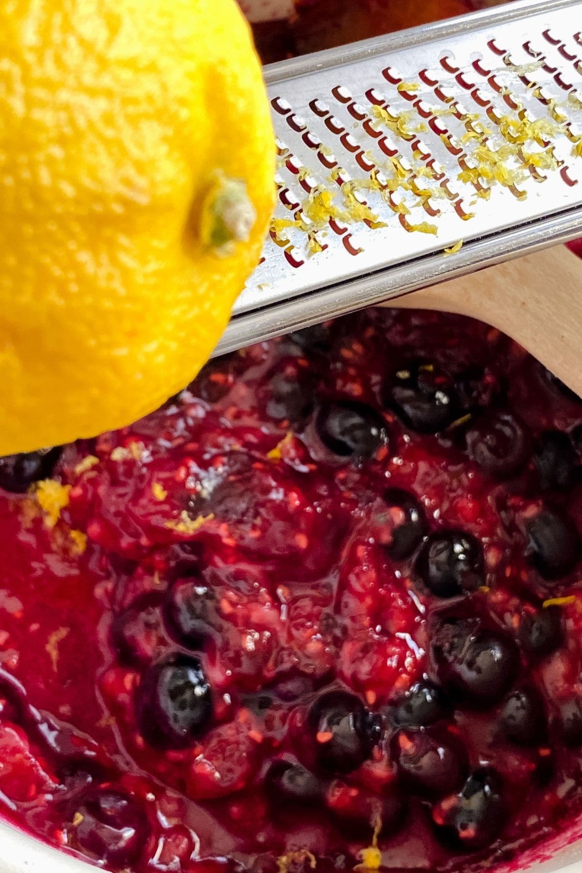 Grating lemon zest into berries
