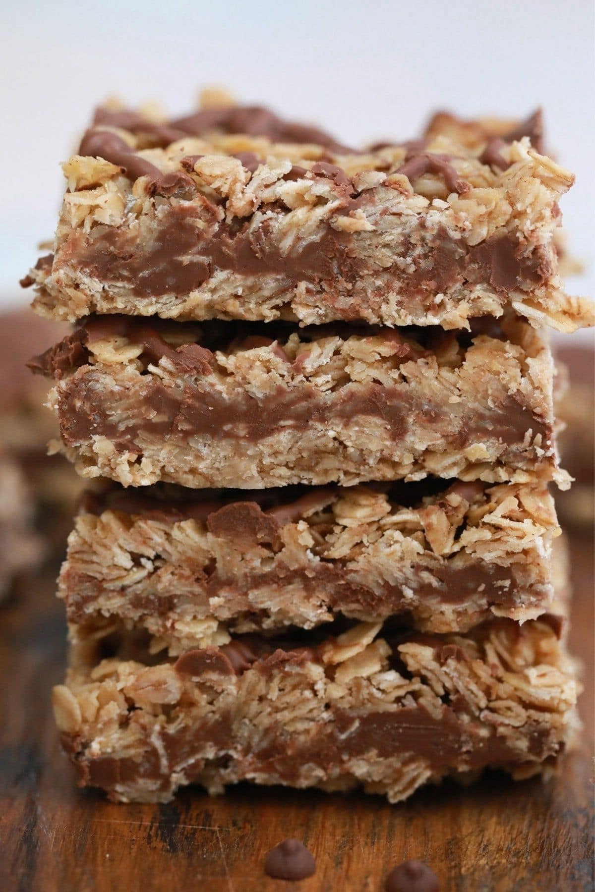 Chocolate peanut butter oatmeal bars stacked on wooden table