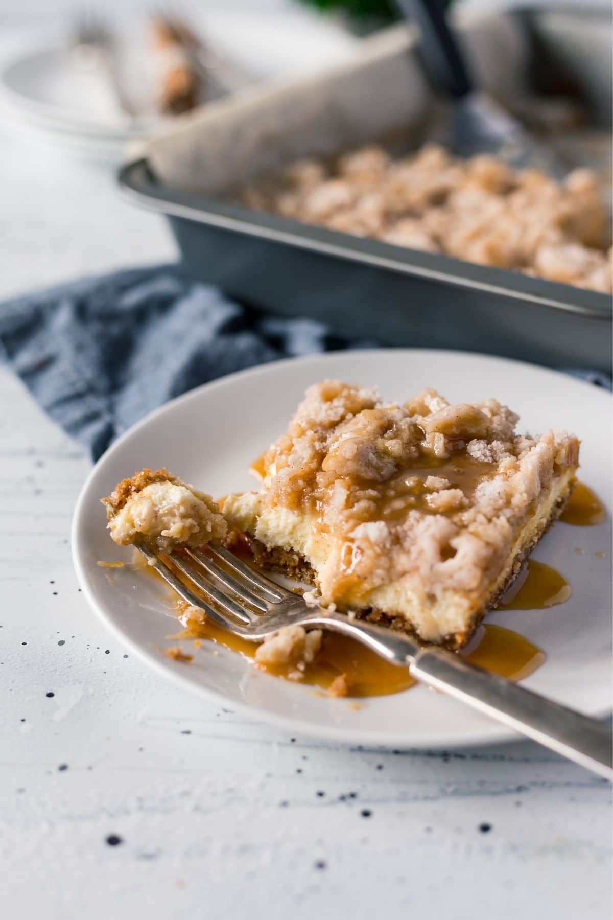 Apple bars with caramel on white plate by pan