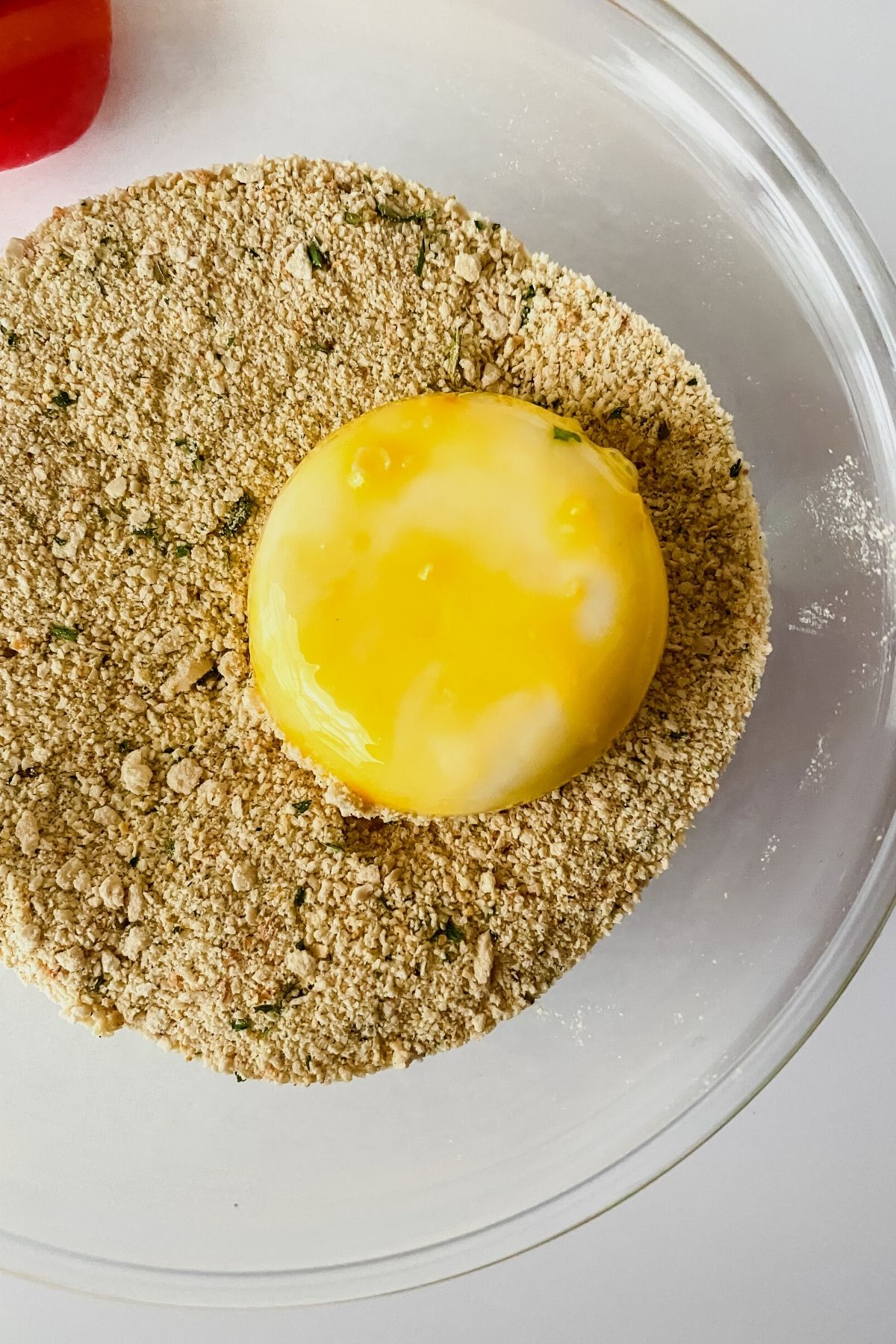 Dredging cheese round into breadcrumbs