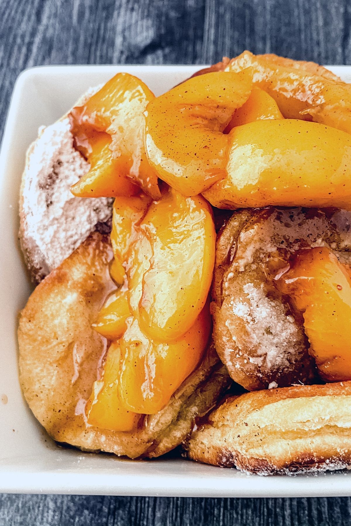 Overhead image of peaches in bowl with fried biscuits