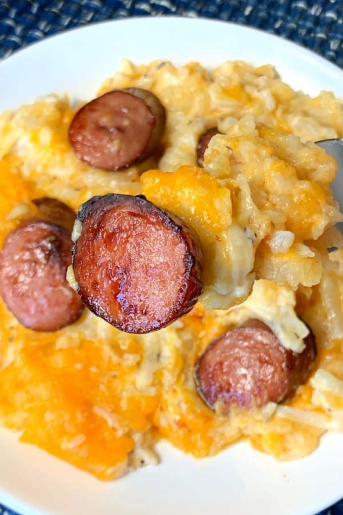 Cheese potatoes on white plate with sausage