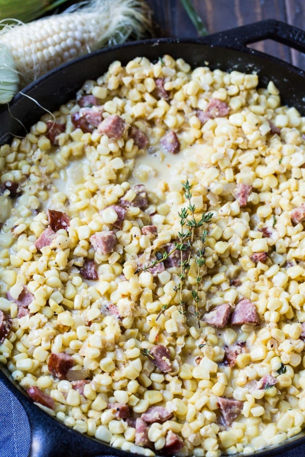 Skillet of corn with pieces of meat throughout