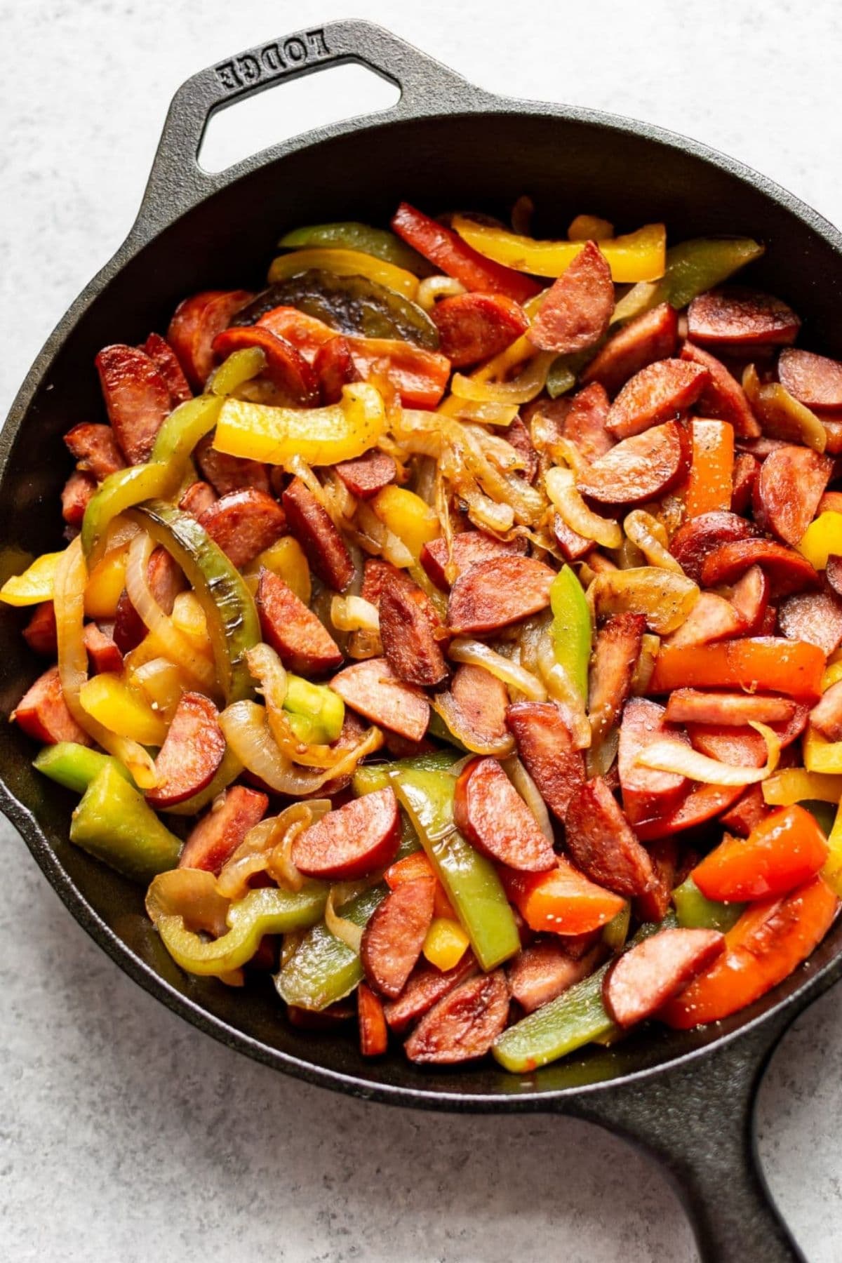 Cast iron skillet filled with sausage and peppers