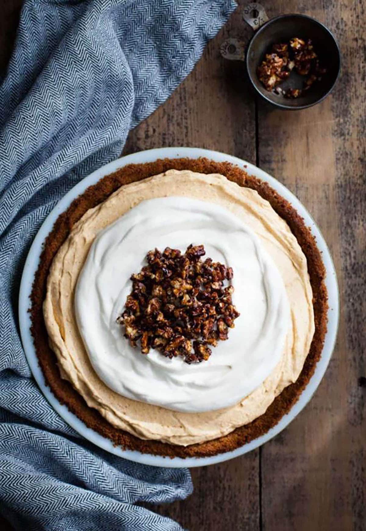 Almost No-Bake Pumpkin Cheesecake Mousse Pie with gingersnap crust and candied pecan toppings