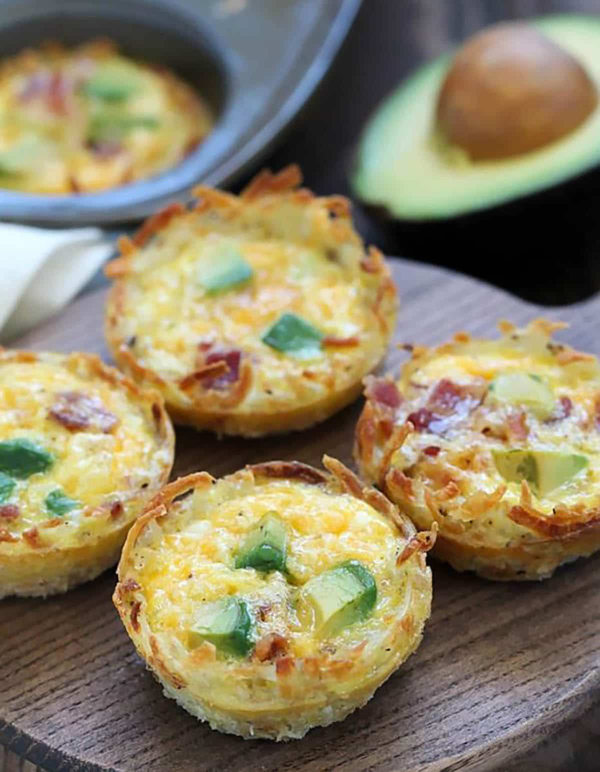 Bacon, Avocado, Hash Brown, Egg Cups on wooden plate