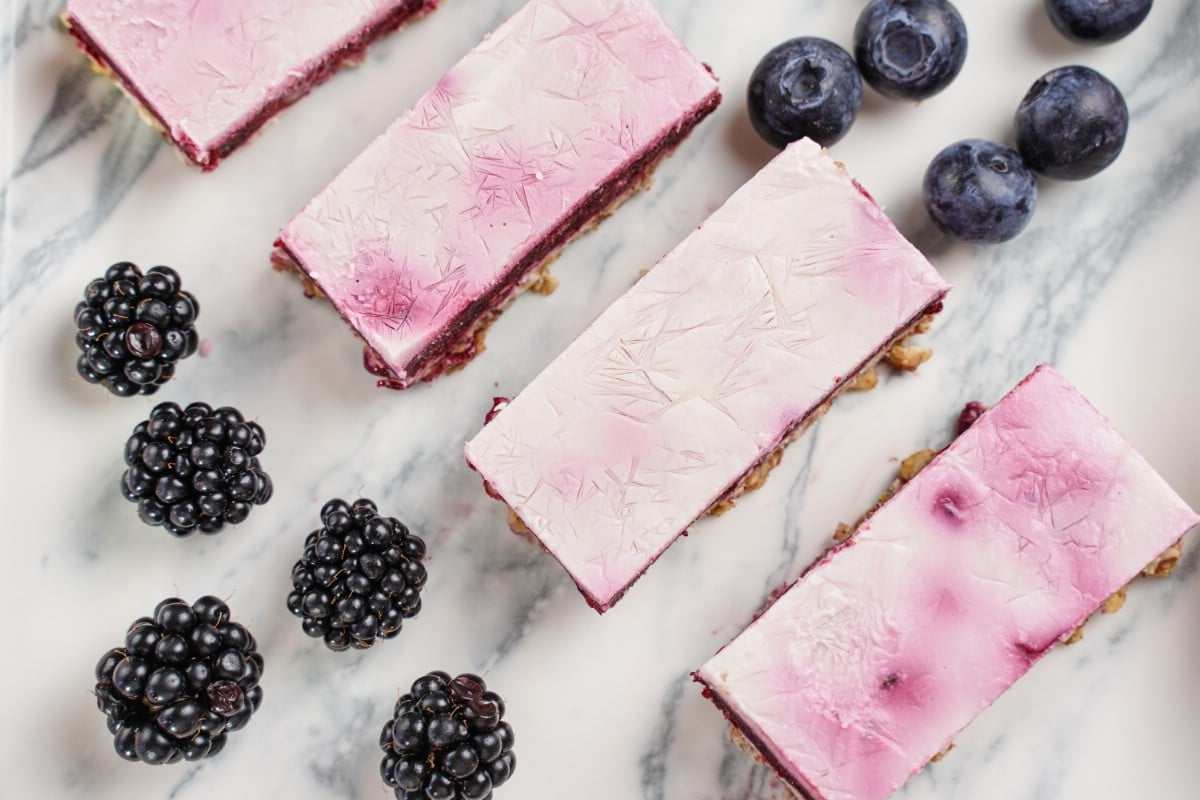 Top of frozen yogurt bars on marble with blackberries beside