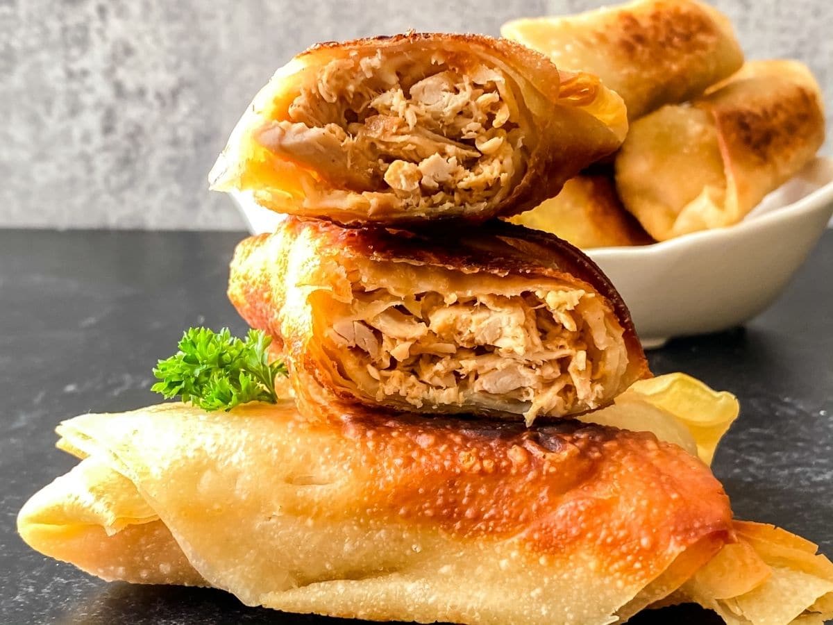 Stacked eggrolls cut in half on gray counter