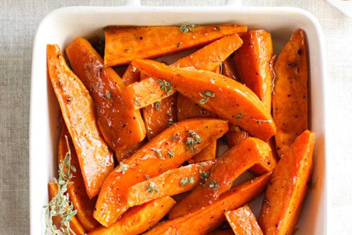 maple buttered sweet potato wedges, served in a white bowl