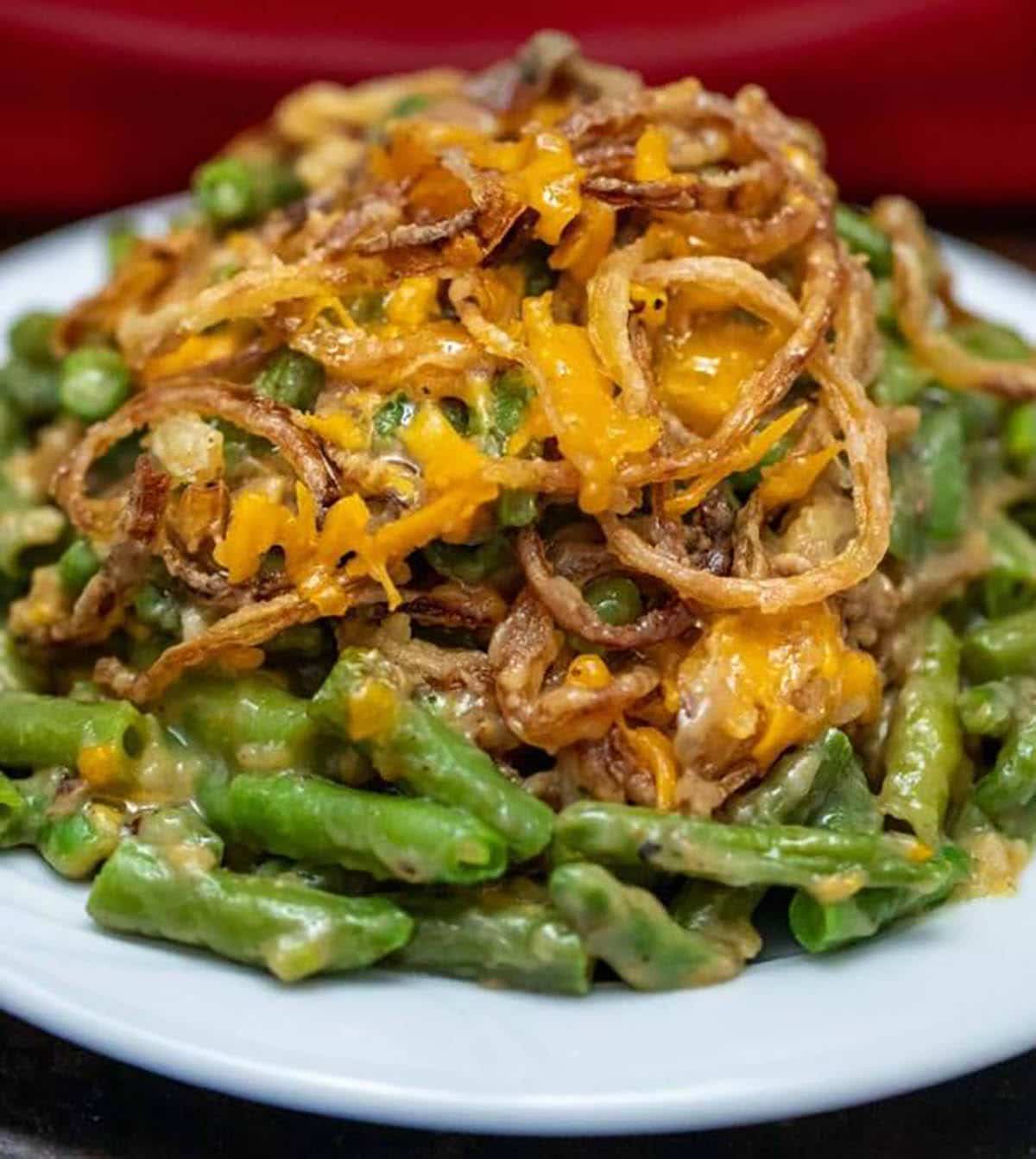 Cheesy Green Bean Casserole topped with cheese and fried onions