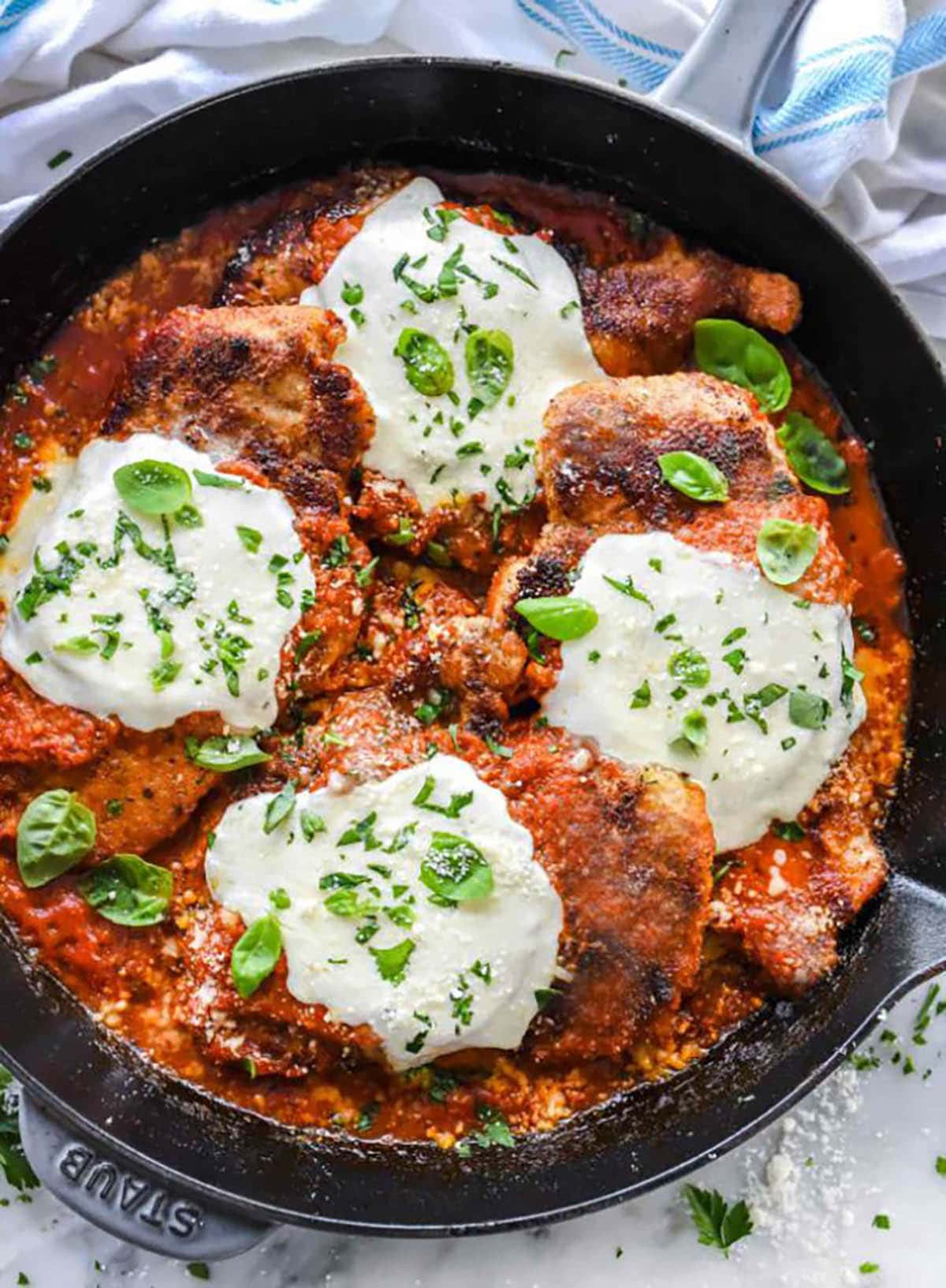 Chicken Parmesan topped with mozzarella and basil leaves