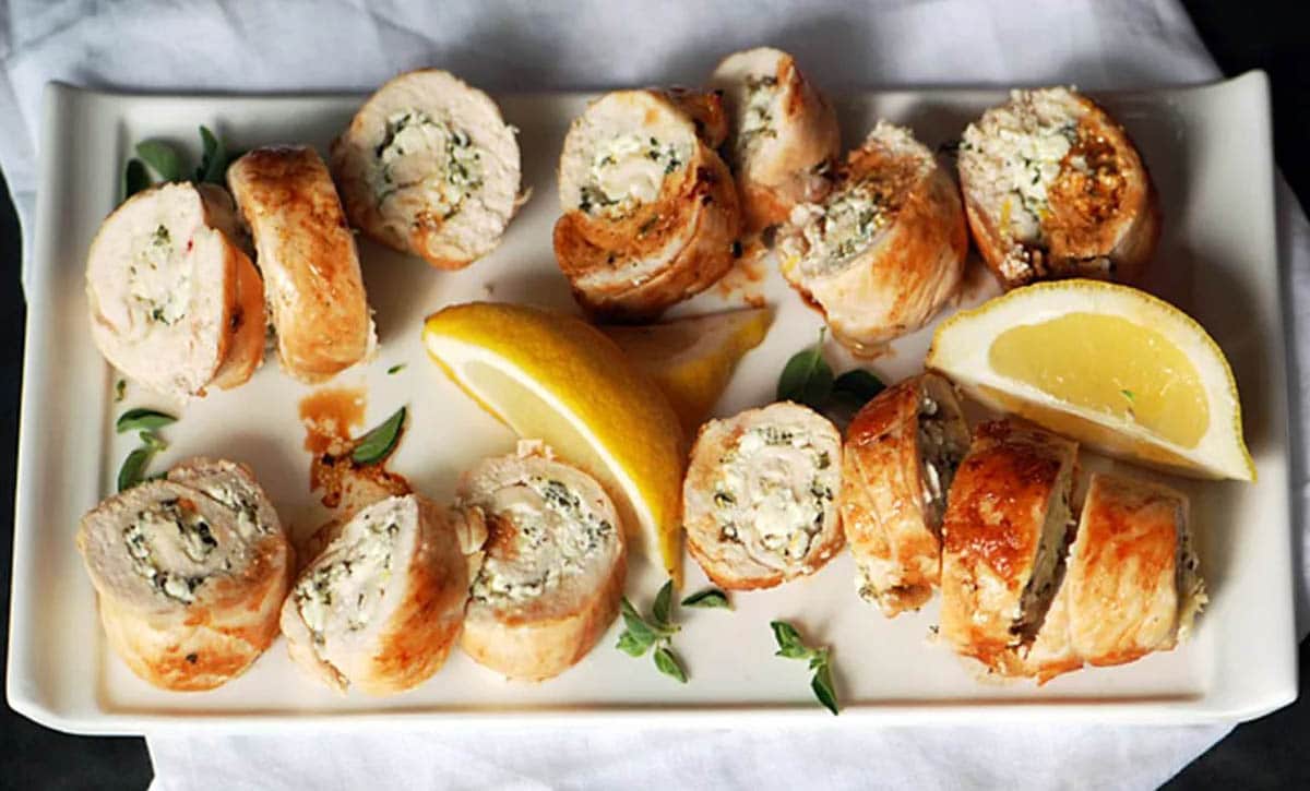 Chicken Roulade with lemon wedges on a plate