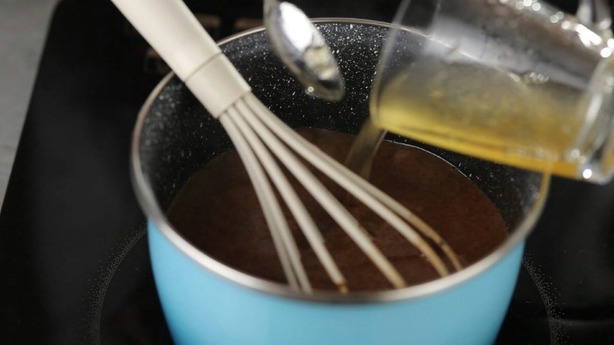Adding gelatin into panna cotta in teal stockpot