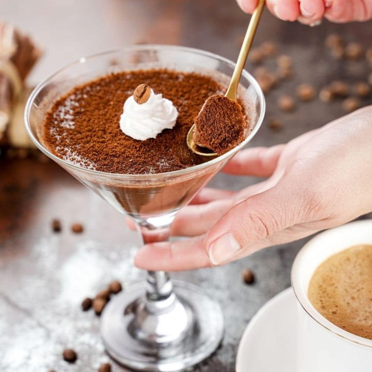 Gold spoon in martini glass of chocolate panna cotta