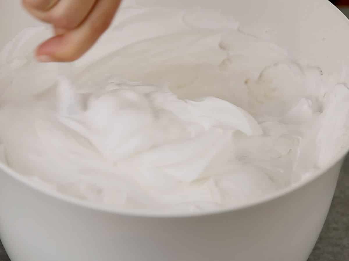 Stirring whipped cream into cream cheese in bowl