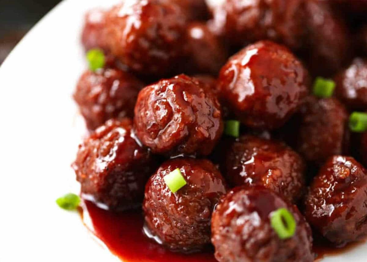 Cockpot Grape Jelly and BBQ Meatballs garnished with chives