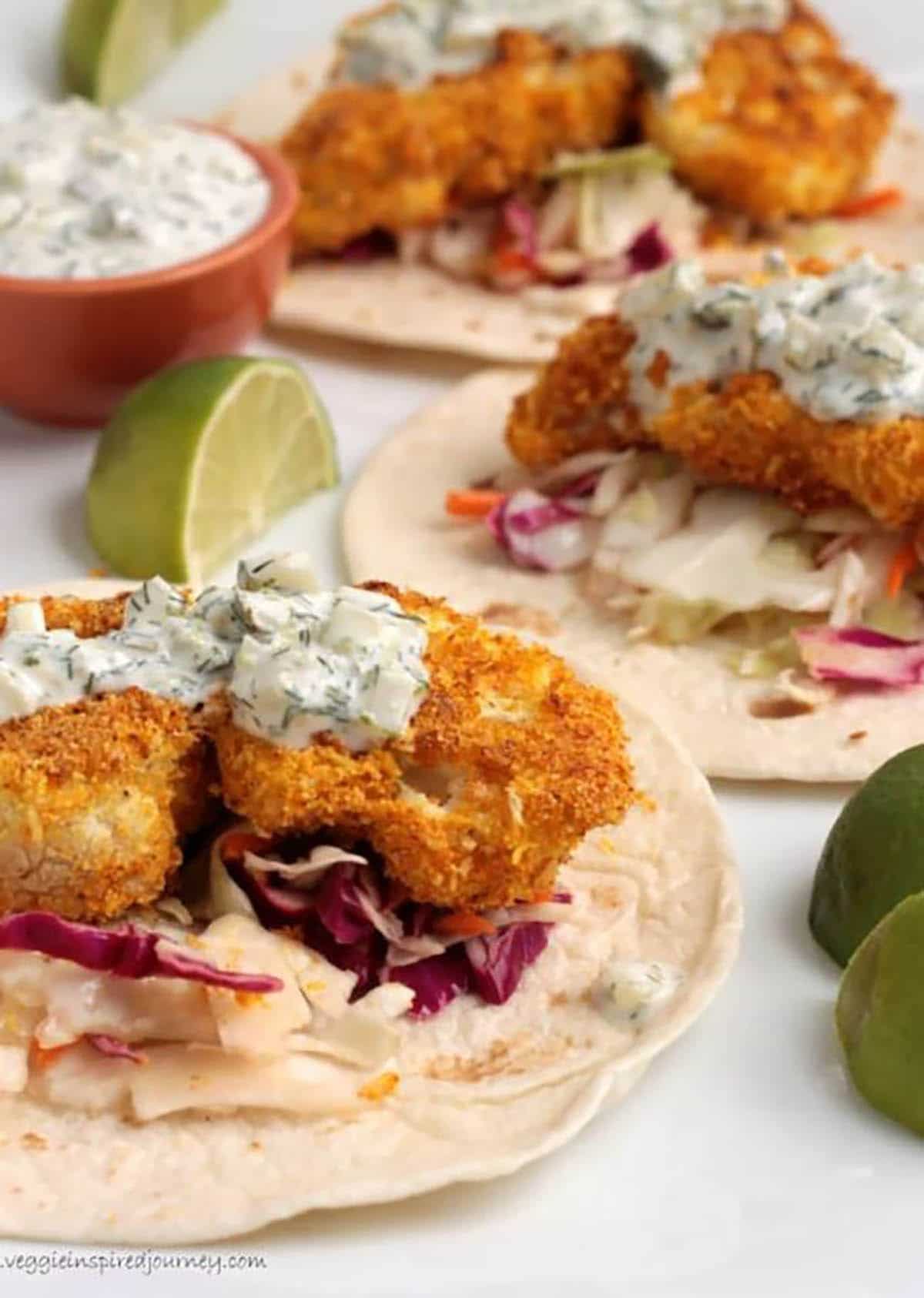 Coconut and lime baked cauliflower tacos topped with tangy tartar sauce