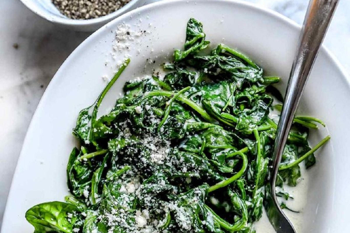 An oval bowl, filled with Creamed Spinach