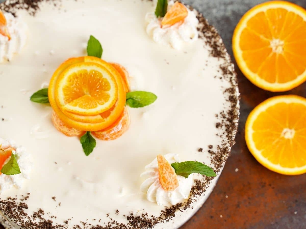 Overhead image of cake with orange slices on side and flower from orange peel on top
