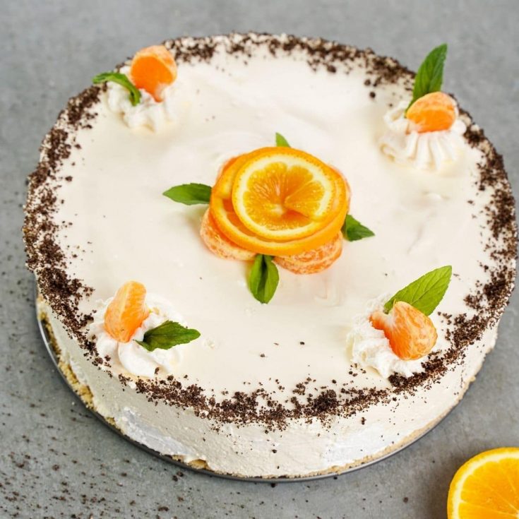 Cheesecake on gray table with orange rind flowers