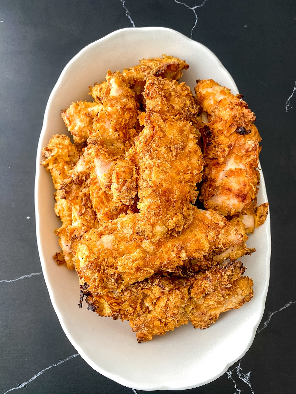 Large white oval bowl filled with chicken tenders