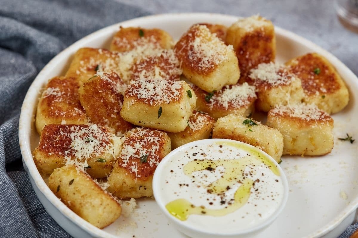Fluffy Cauliflower Gnocchi on a plate with dip on the side
