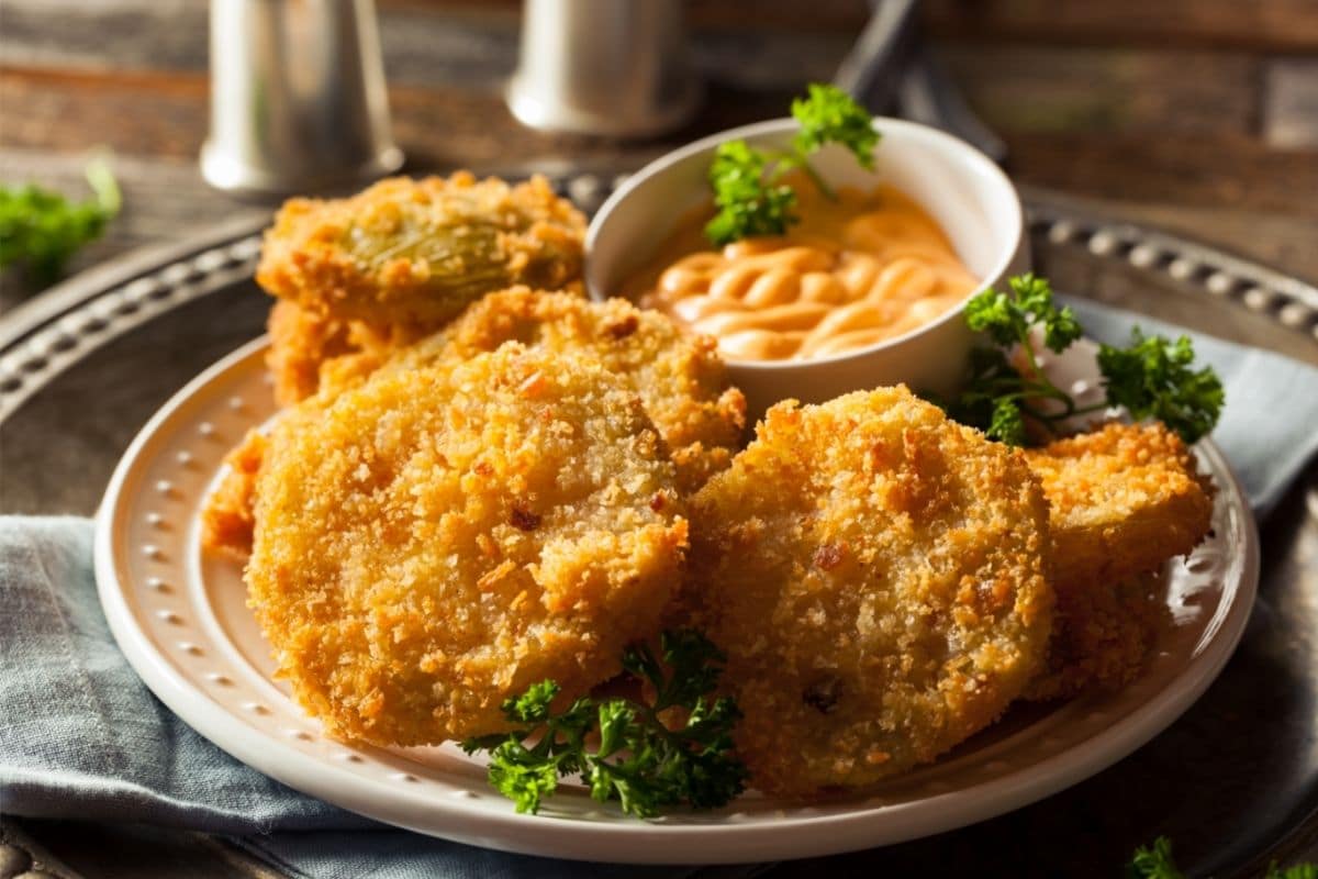 a plate of breaded Fried Green Tomatoes with dip