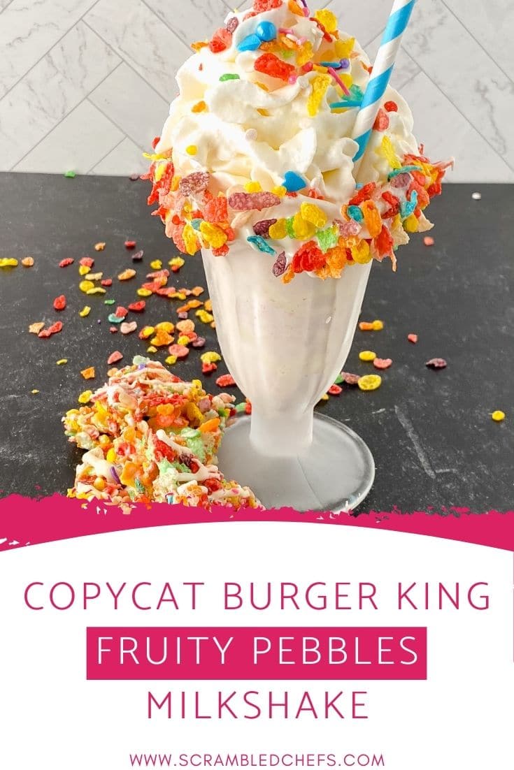 Glass of milkshake topped with colorful cereal on black table with overlay at bottom of image saying copycat burger king fruity pebbles milkshake