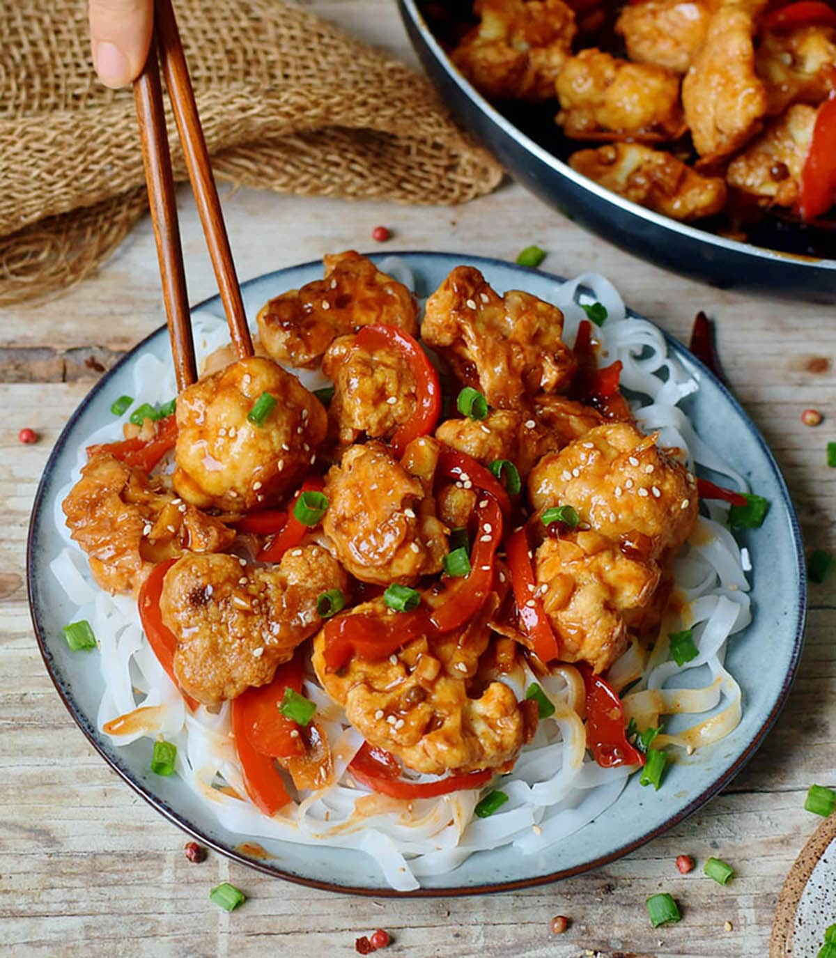 Kung Pao cauliflower topped with bell peppers and chives 