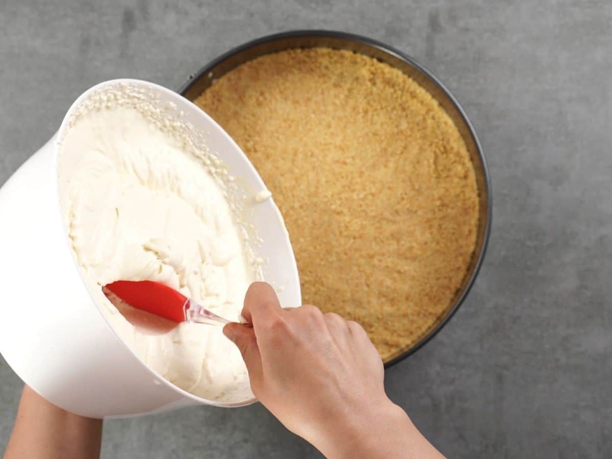 Pouring pie filling into graham cracker crust