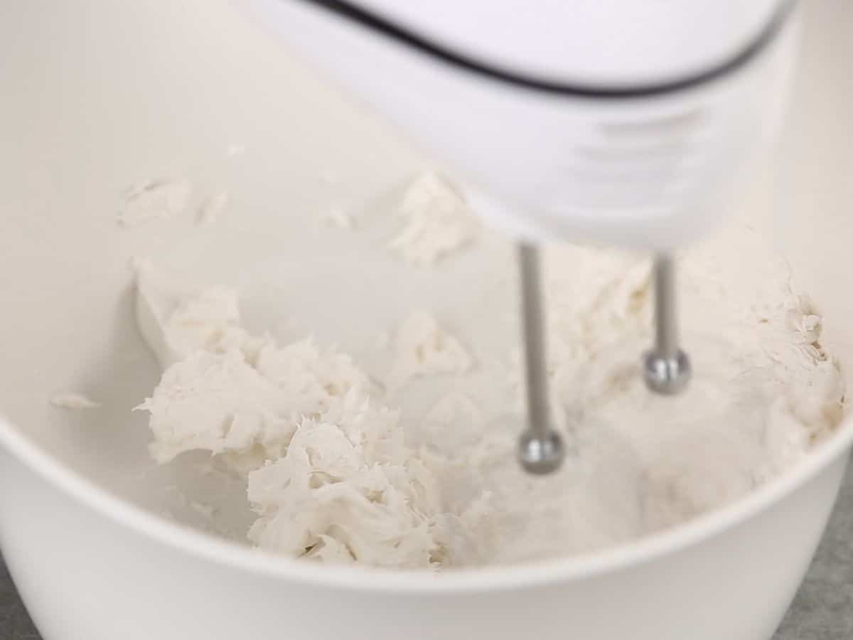 Cream cheese being mixed in bowl