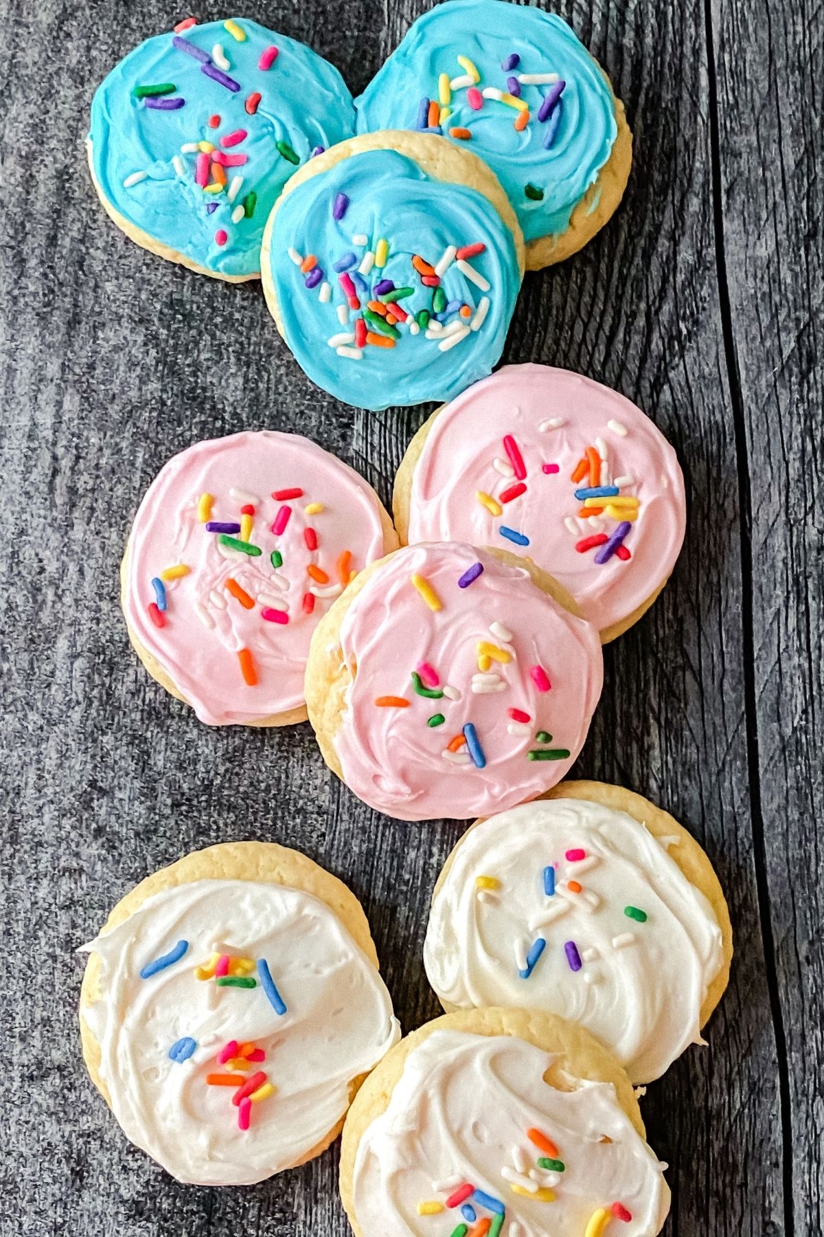Blue pink and white frosted cookies on black table