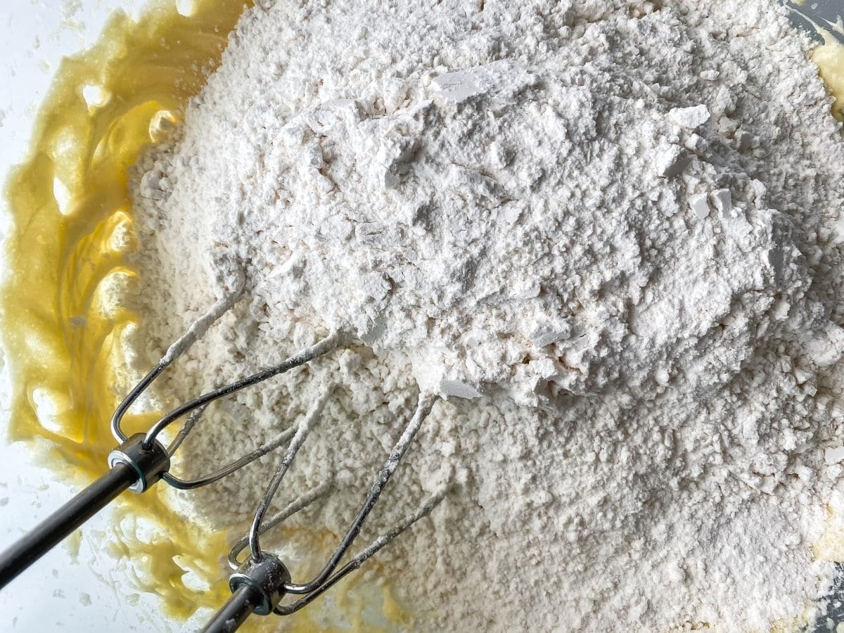 Flour on top of creamed egg and sugar in mixing bowl