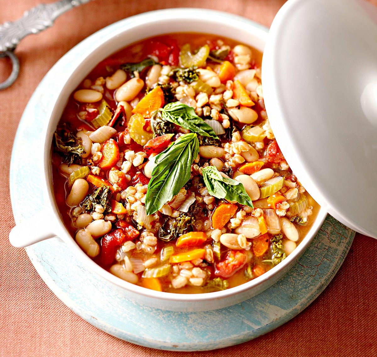 Mediterranean Farro Stew topped with basil in a pot
