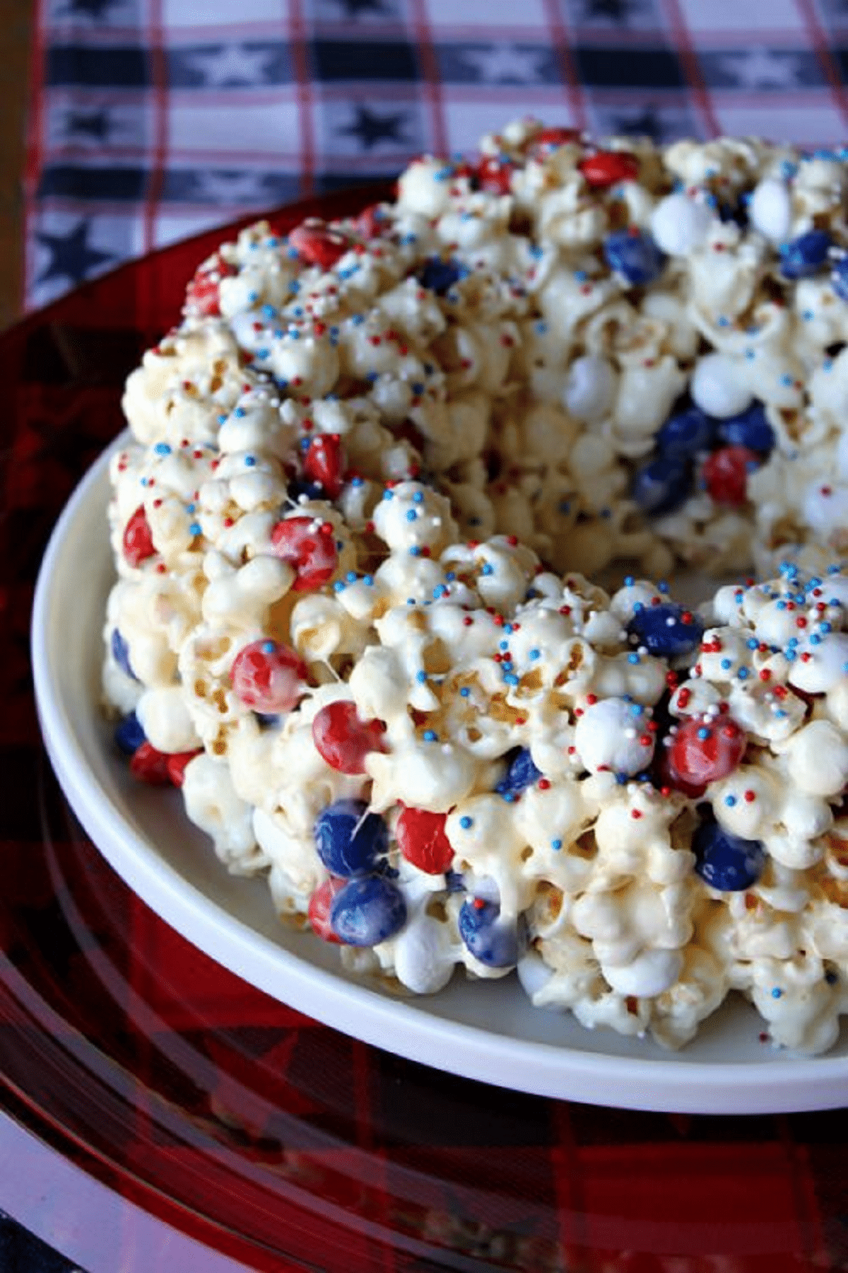 Marshmallow popcorn bundt ring with sprinkles sitting on white plate