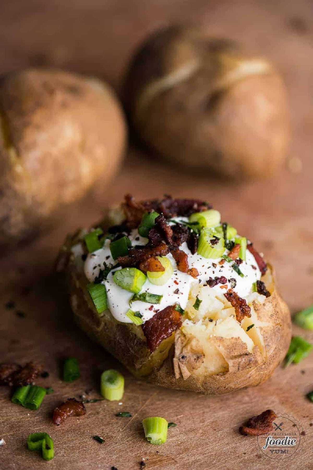 Baked potatoes with sour cream, bacon, green onions and chives