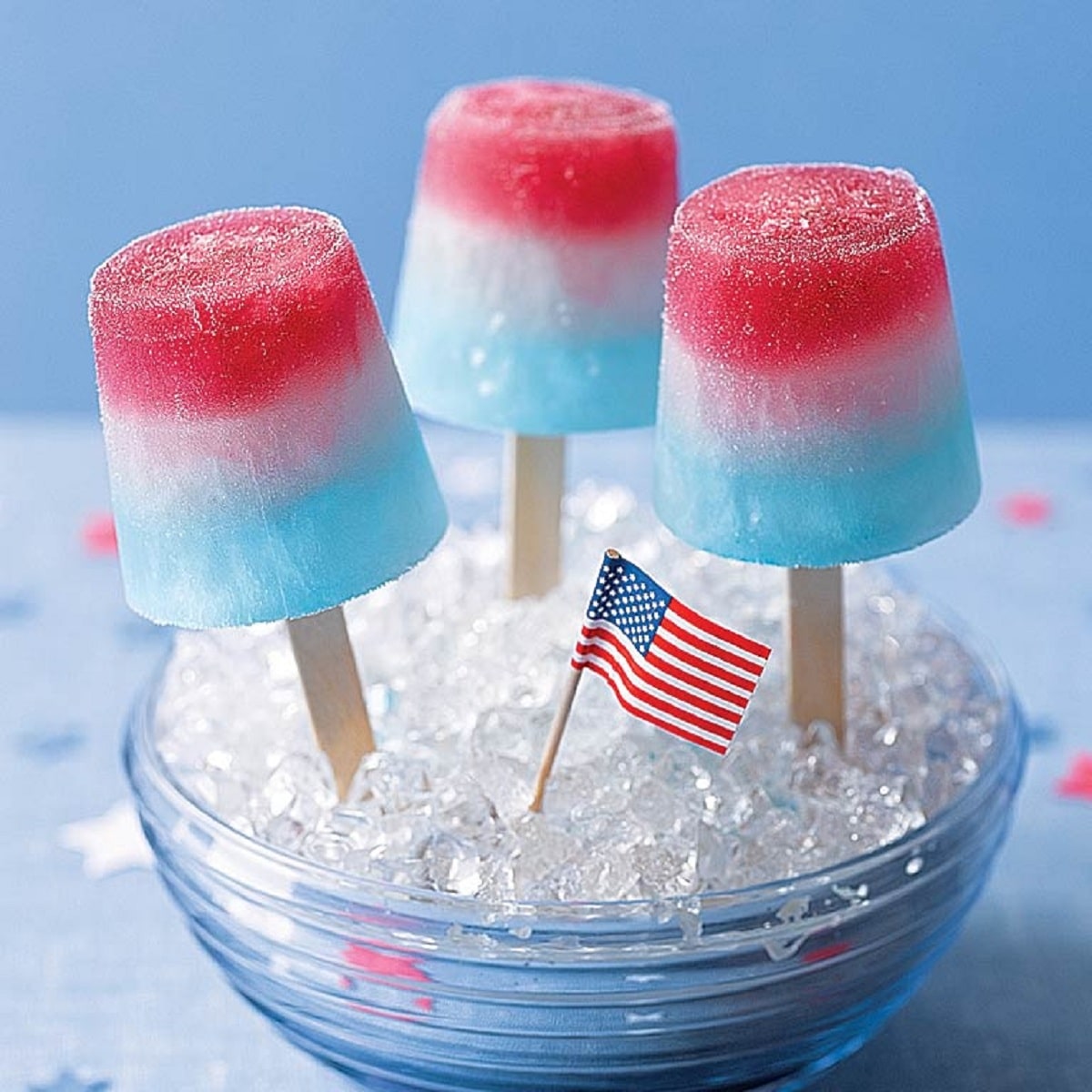 Red white and blue ice pops in ice in blue bowl with mini flag in ice