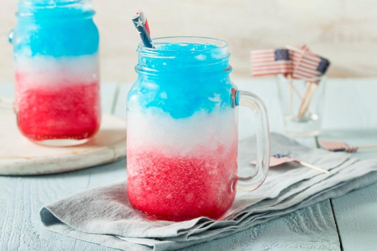 Mason jar mug filled with crushed ice in blue white and red colors on gray napkin