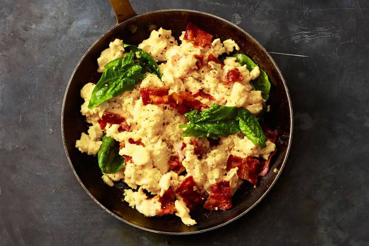 Scrambled Eggs topped with basil and bacon