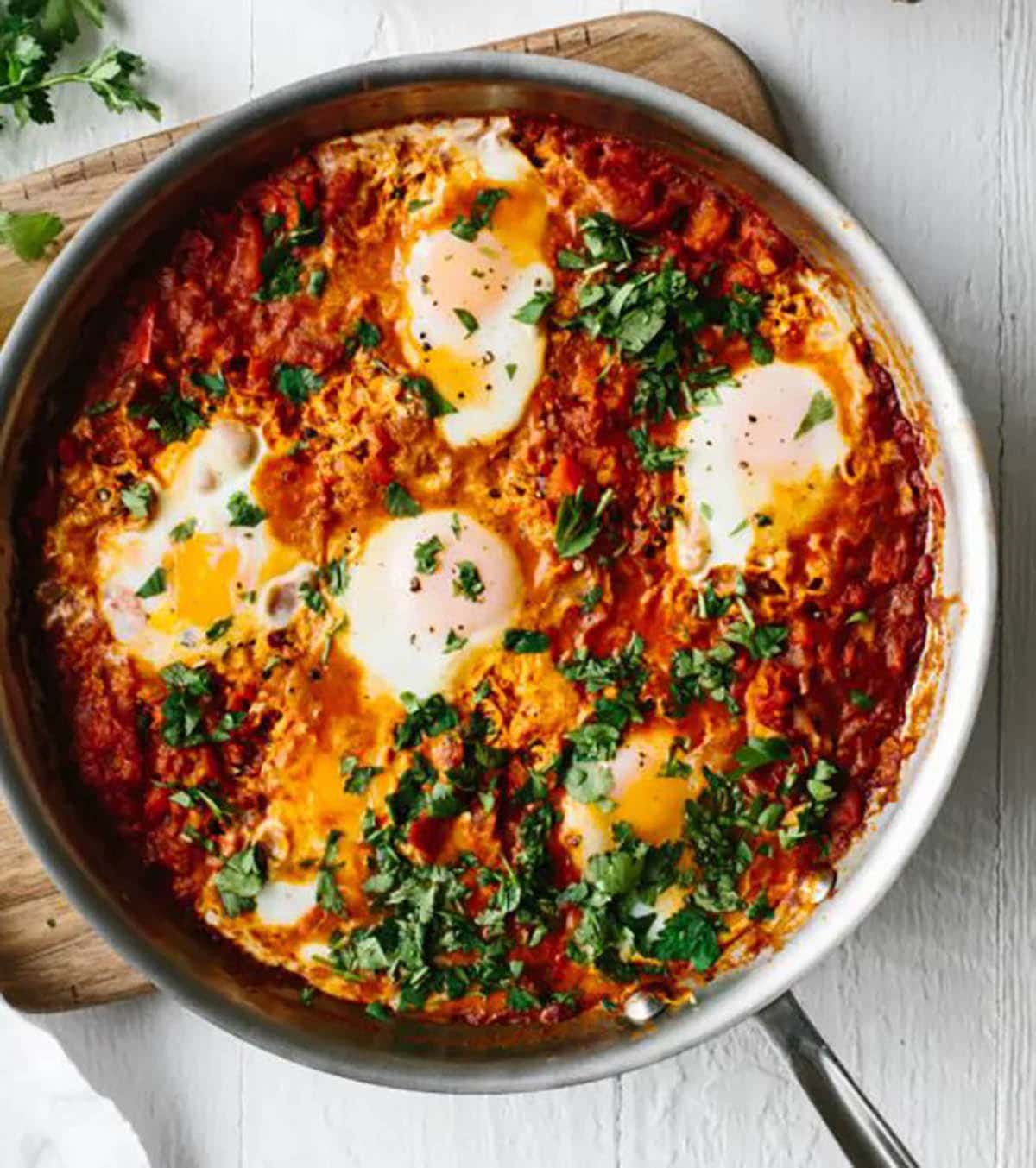 Shakshuka (poached eggs in tomato sauce topped with parsley and cilantro)