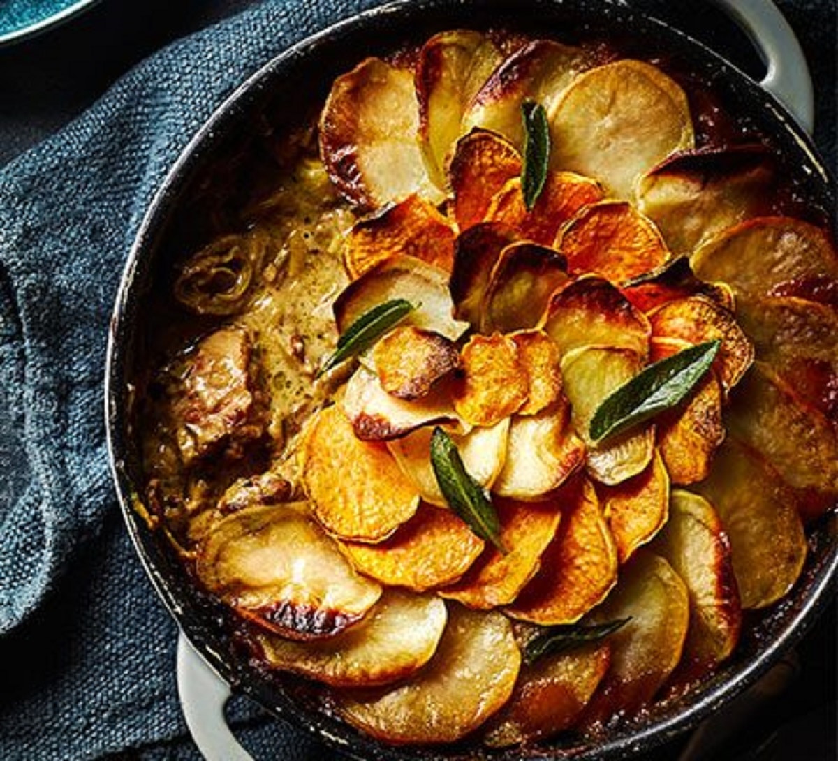 Slow-cooked pork, cider, and sage hotpot in a pan