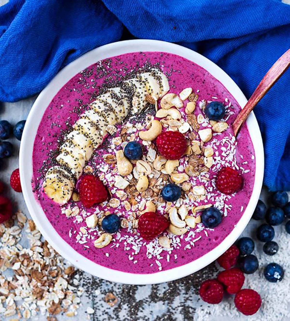 Smoothie Bowls topped with chia seeds, sliced banana, cashews, raspberries, and blueberries